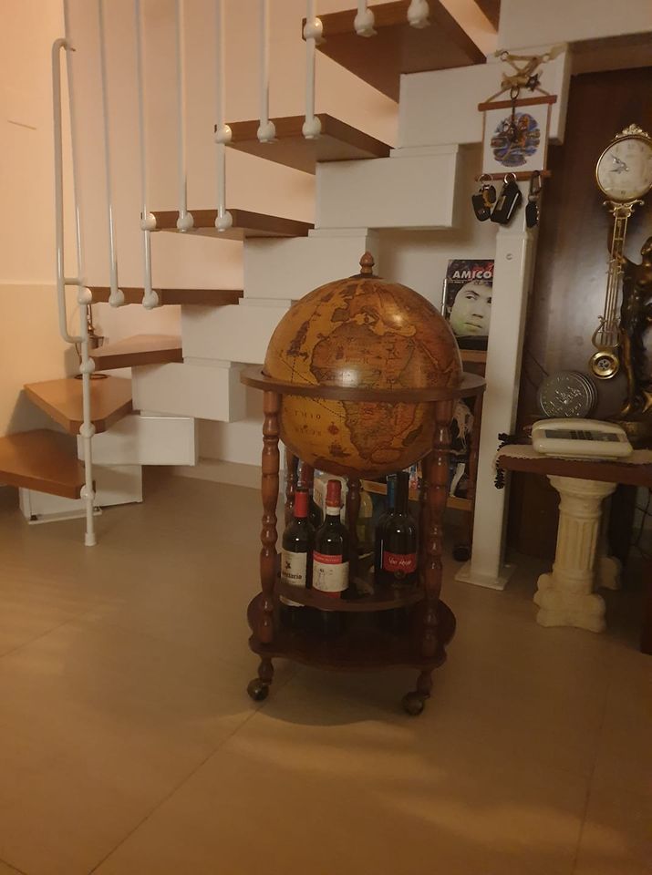 Mappamondo bar Zoffoli con cartografia classica vicino a una scala interna.
