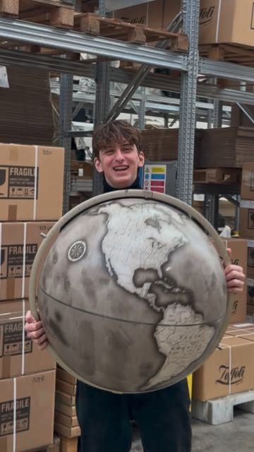 Cliente con una sfera geografica in bianco e nero nel laboratorio Zoffoli.