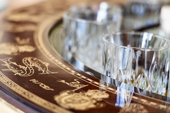 Zoffoli Afrodite: close-up of the globe bar's ornate wooden tray, glasses and whisky decanter.