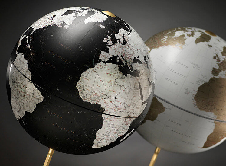 Dettaglio di due mappamondi con cartografia in bianco, nero e oro.