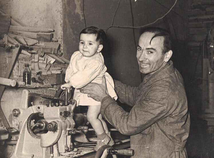 Fotografia storica in bianco e nero di un uomo con una bambina in laboratorio.