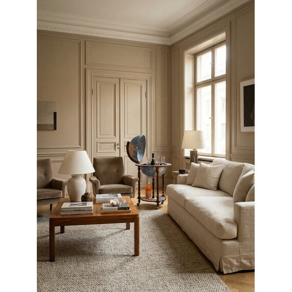 Zoffoli Da Vinci Blue Dust globe bar styled in a bright living room with a sofa and armchair.
