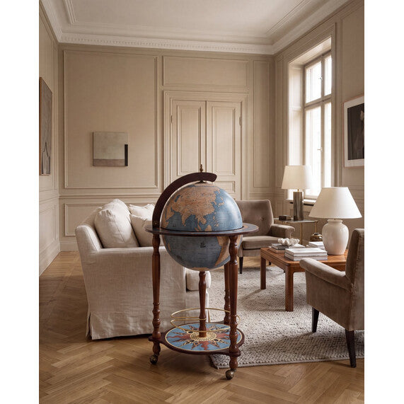 Da Vinci Blue Dust floor-standing globe bar by Zoffoli beside a sofa in a neutral living room.