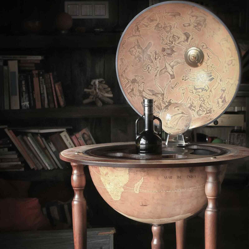 Da Vinci Rust globe bar by Zoffoli, open with bottles and glasses in a dark study.