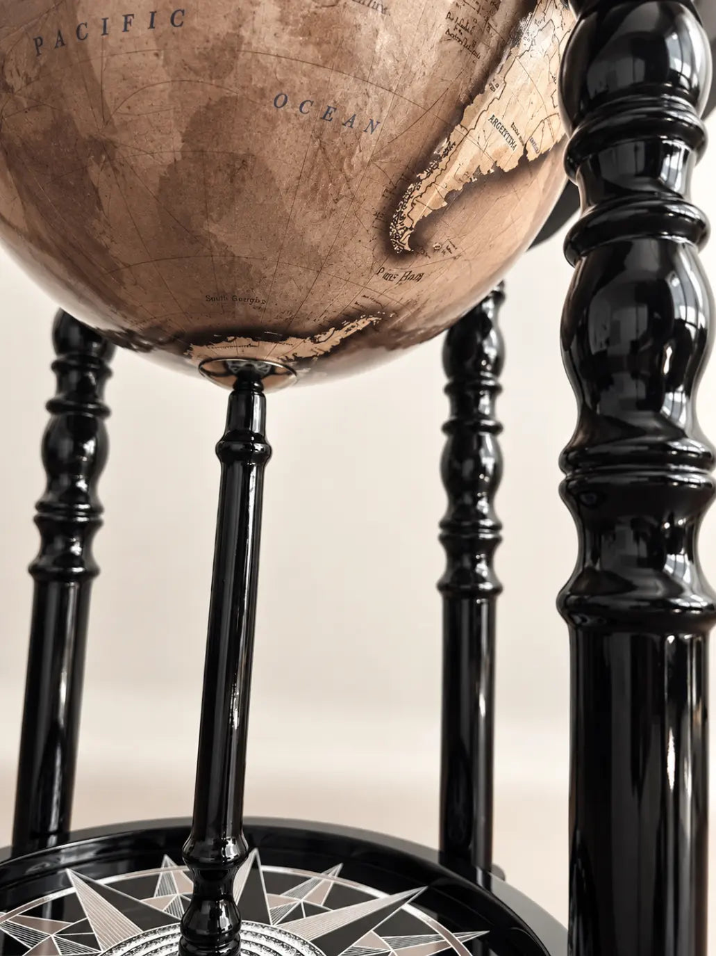 Zoffoli Elegance: detail of the Noir globe bar's pale map and turned black wooden legs.