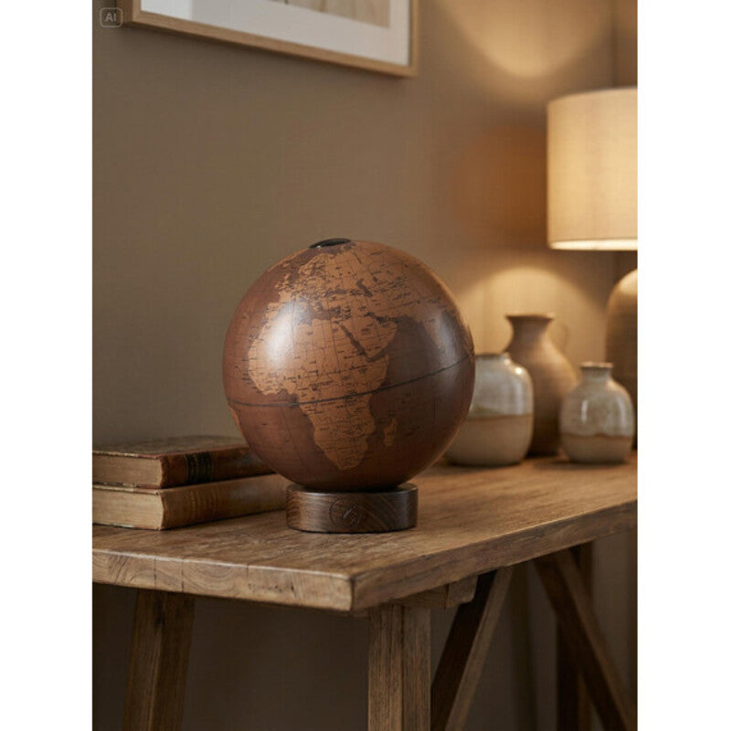 Zoffoli Orbis: Tecnocuoio globe on a console table beside a lamp.